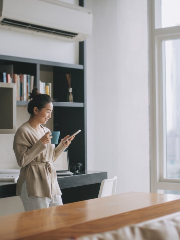 woman standing in kitchen on her phone